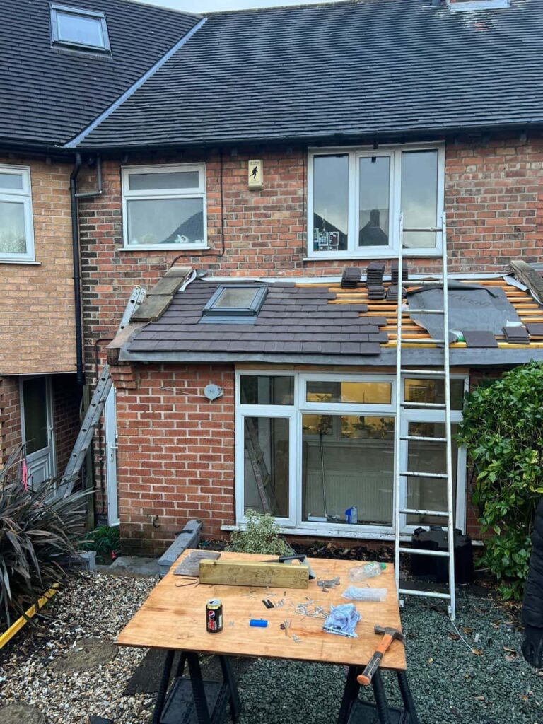 This is a photo of a roof extension that is having new roof tiles installed. This is a photo taken from the roof ridge looking down a tiled pitched roof on to a flat roof. Works carried out by Clay Cross Roofing Repairs