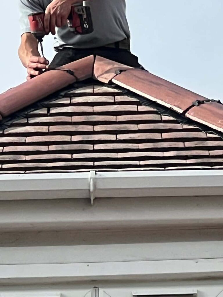 This is a photo of one of the operatives of Clay Cross Roofing Repairs installing new ridge tiles